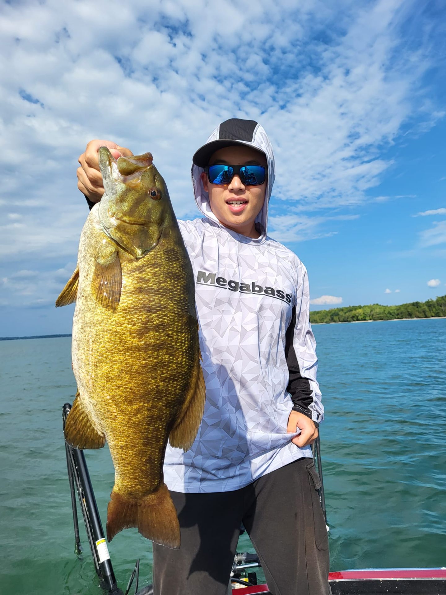 Trophy smallmouth bass held up on the boat